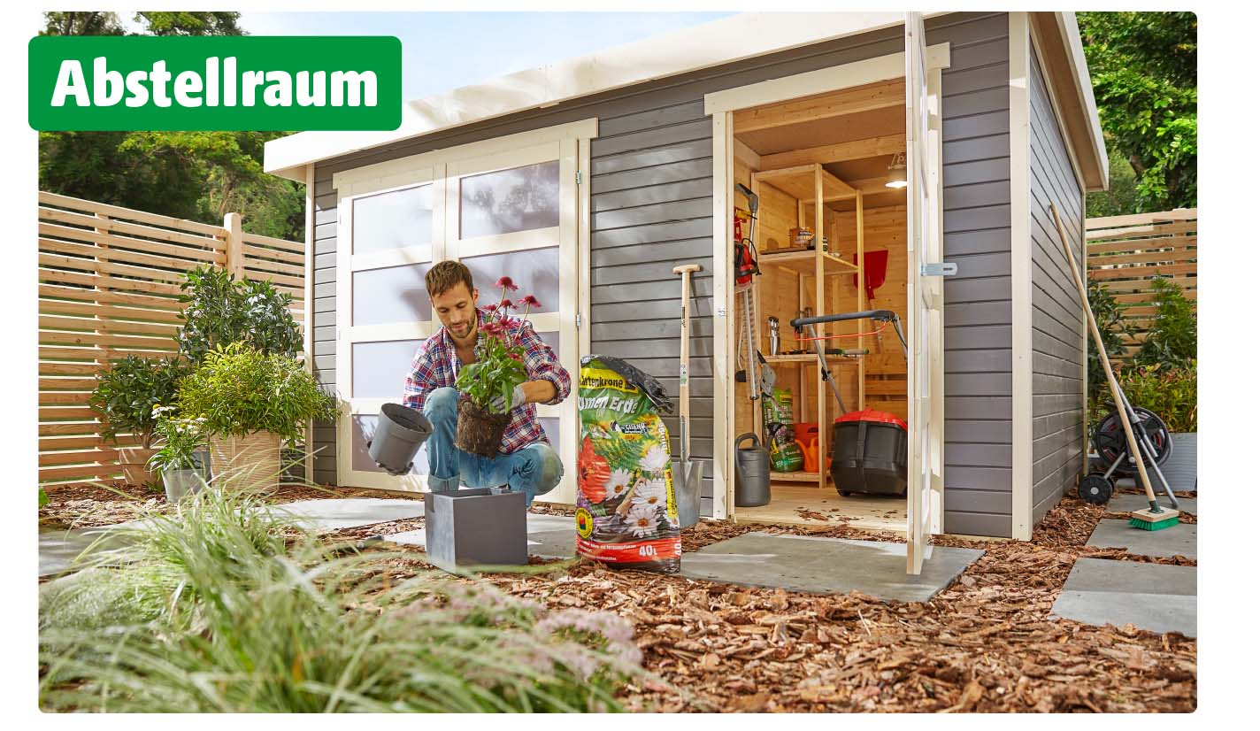 Ein Mann pflanzt Blumen vor einem Gartenhaus, das als praktischer Abstellraum dient. Im Hintergrund sind geöffnete Türen zu sehen, durch die Regale mit Gartengeräten, Blumenerde und ein Rasenmäher sichtbar werden. Oben links steht in weißer Schrift auf grünem Hintergrund das Wort Abstellraum.