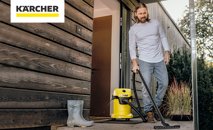 Ein Mann verwendet einen Kärcher Staubsauger vor seiner Haustür