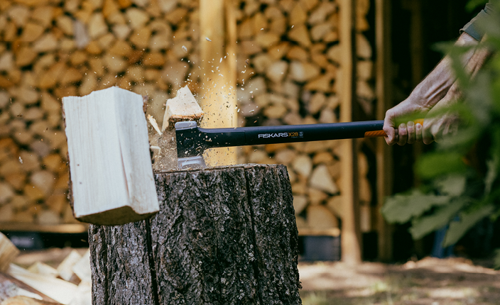 Abbildung von einer Fiskars Axt die Holz spaltet