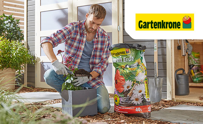 Ein Mann packt Erde in einen Blumenkasten