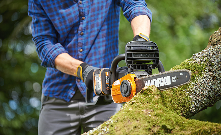 Ein Mann schneidet Holz mit einer Worx Kettensäge