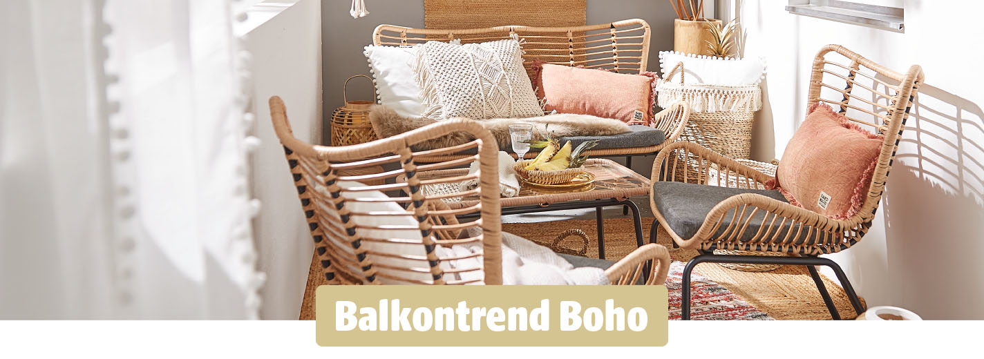 Boho-inspirierte Sitzecke auf dem Balkon mit geflochtenen Sesseln, gemütlichen Kissen, Naturmaterialien und sanften Farben.