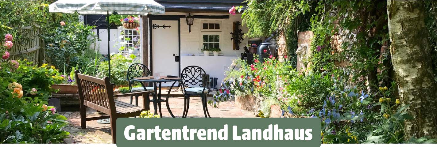 Garten im Landhausstil mit verspielten Gartenmöbeln, Blumenbeeten und viel Grün.
