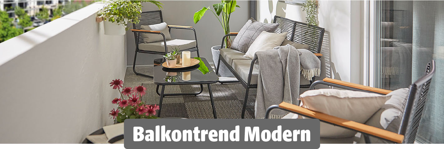 Moderner Balkon mit schwarzem Metallgestell-Mobiliar, grauen Polstern, minimalistischem Couchtisch, Pflanzendeko und gemütlichen Kissen und Decken.