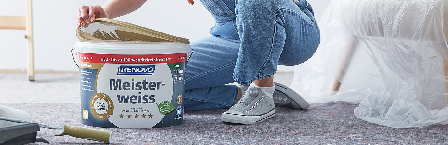 Frau öffnet Farbeimer der Marke RENOVO
