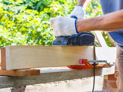 Mann mit Hobel bearbeitet Holzlatte