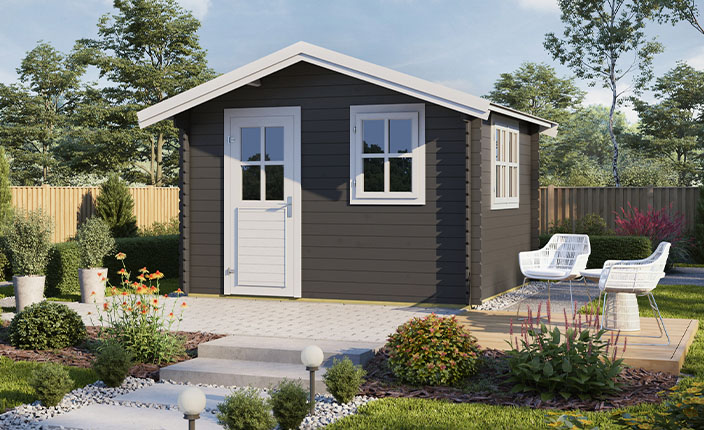 Ein dunkles Holzgartenhaus steht in einem Garten.