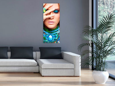 Eine dekorative Infrarotheizung in Form eines bunten Bildes hängt an der Wand über einem modernen Ecksofa im Wohnzimmer