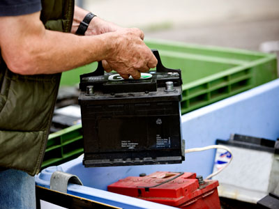 Mann entsorgt Autobatterie