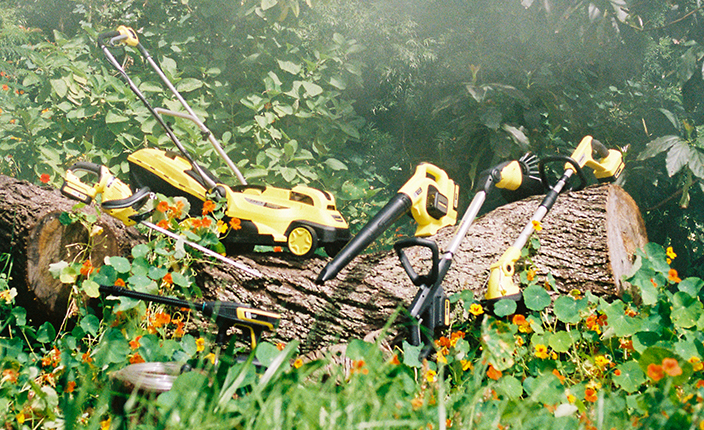 Kärcher Geräte liegen auf einem Baumstamm in der Natur